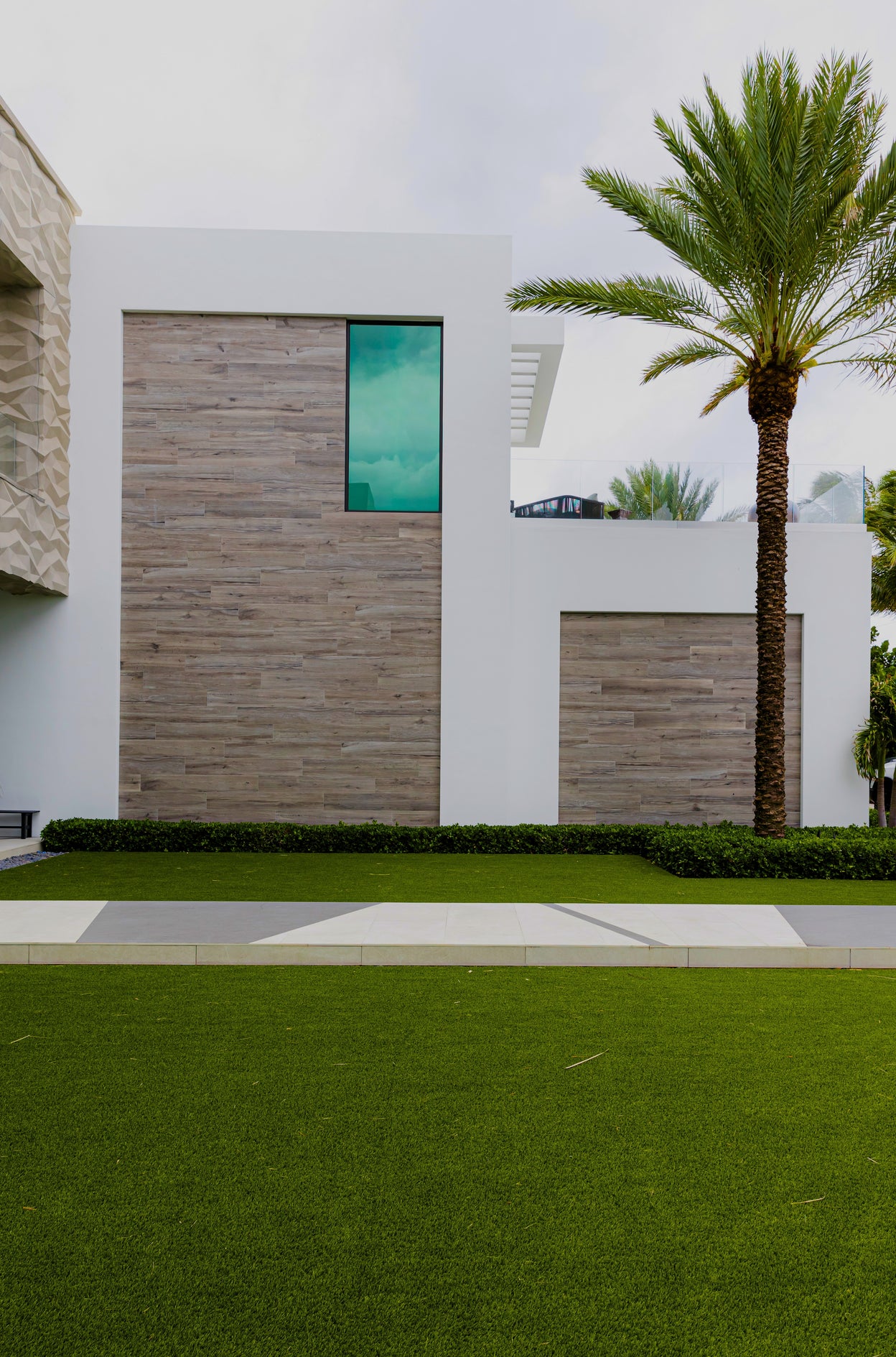Modern building with wooden paneling and a palm tree in front