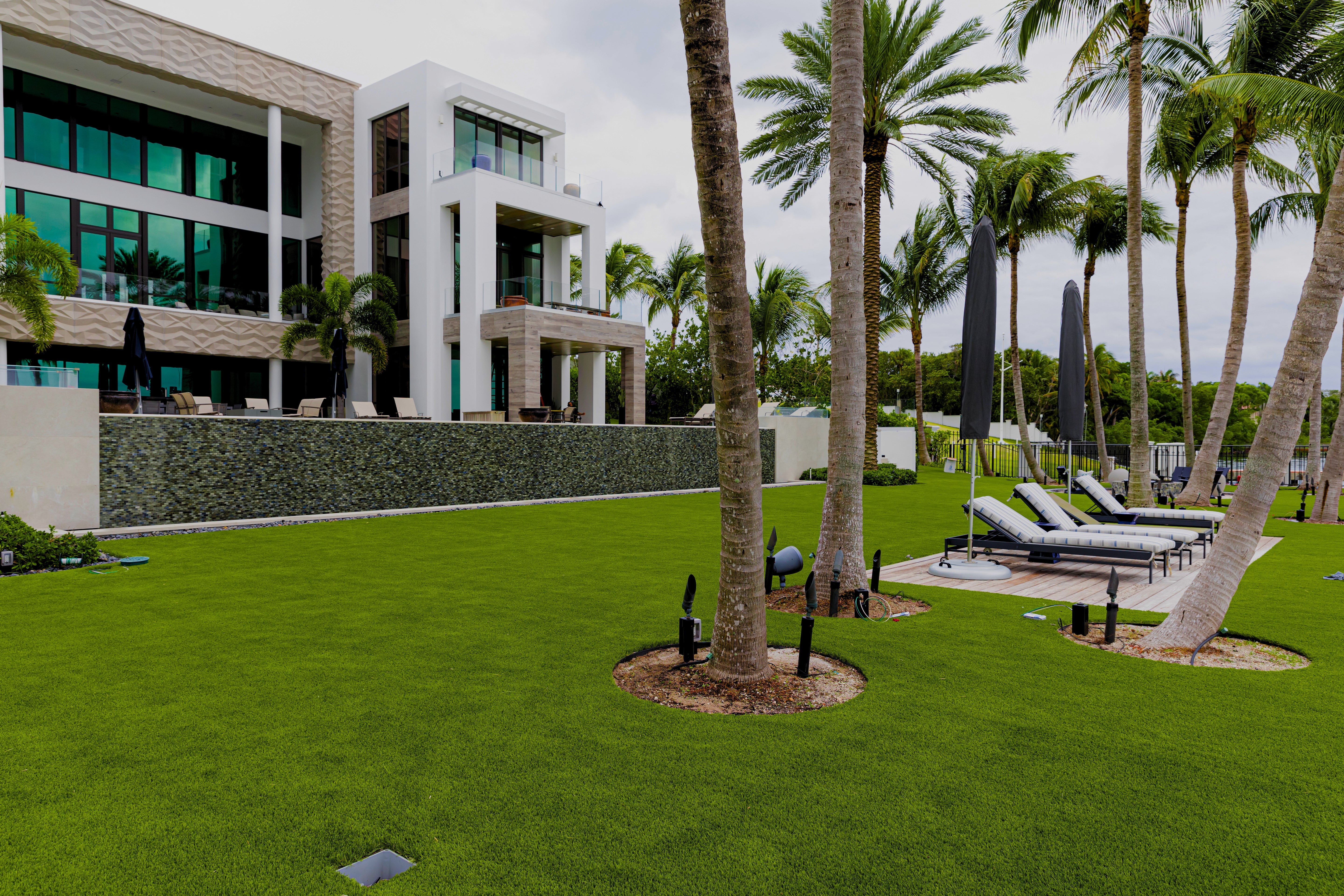 Modern building with palm trees and lounge chairs in a luxurious outdoor setting