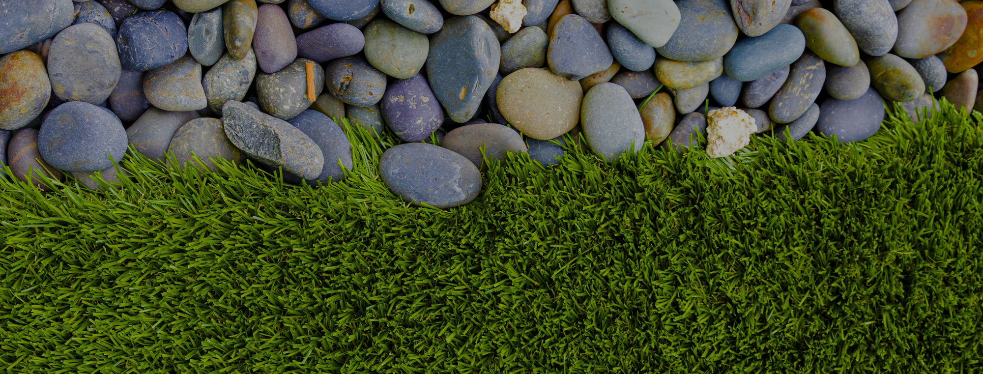 Artificial grass with a border of natural stones
