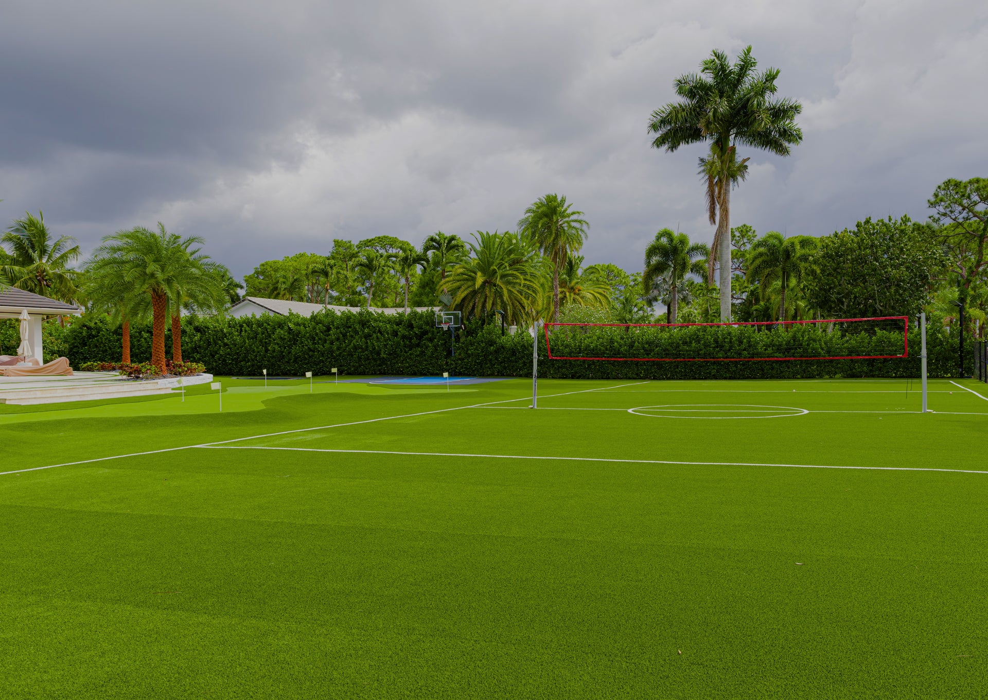 Tennis court with palm trees and a cloudy sky