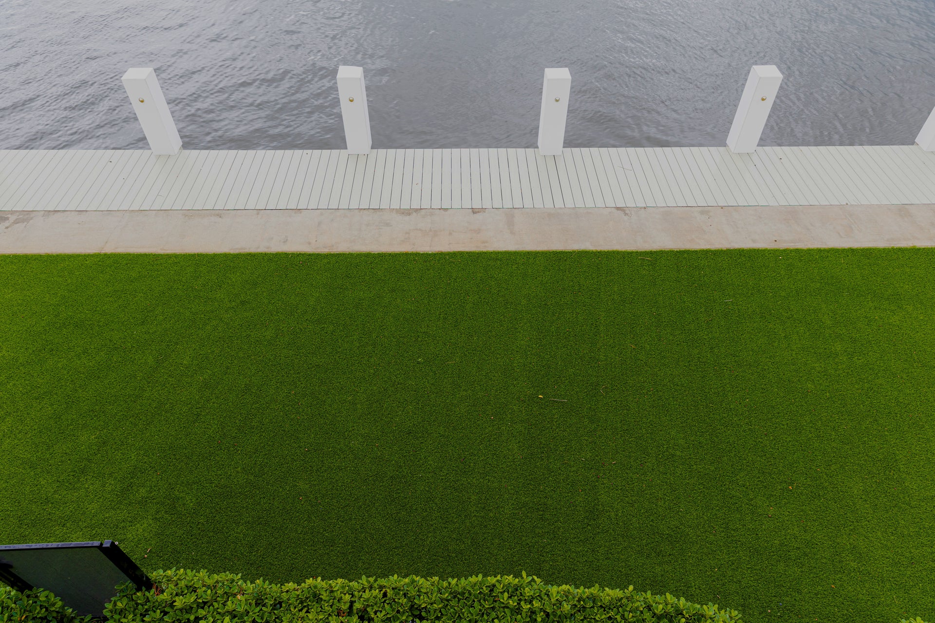 Green lawn with a white pathway leading to a body of water