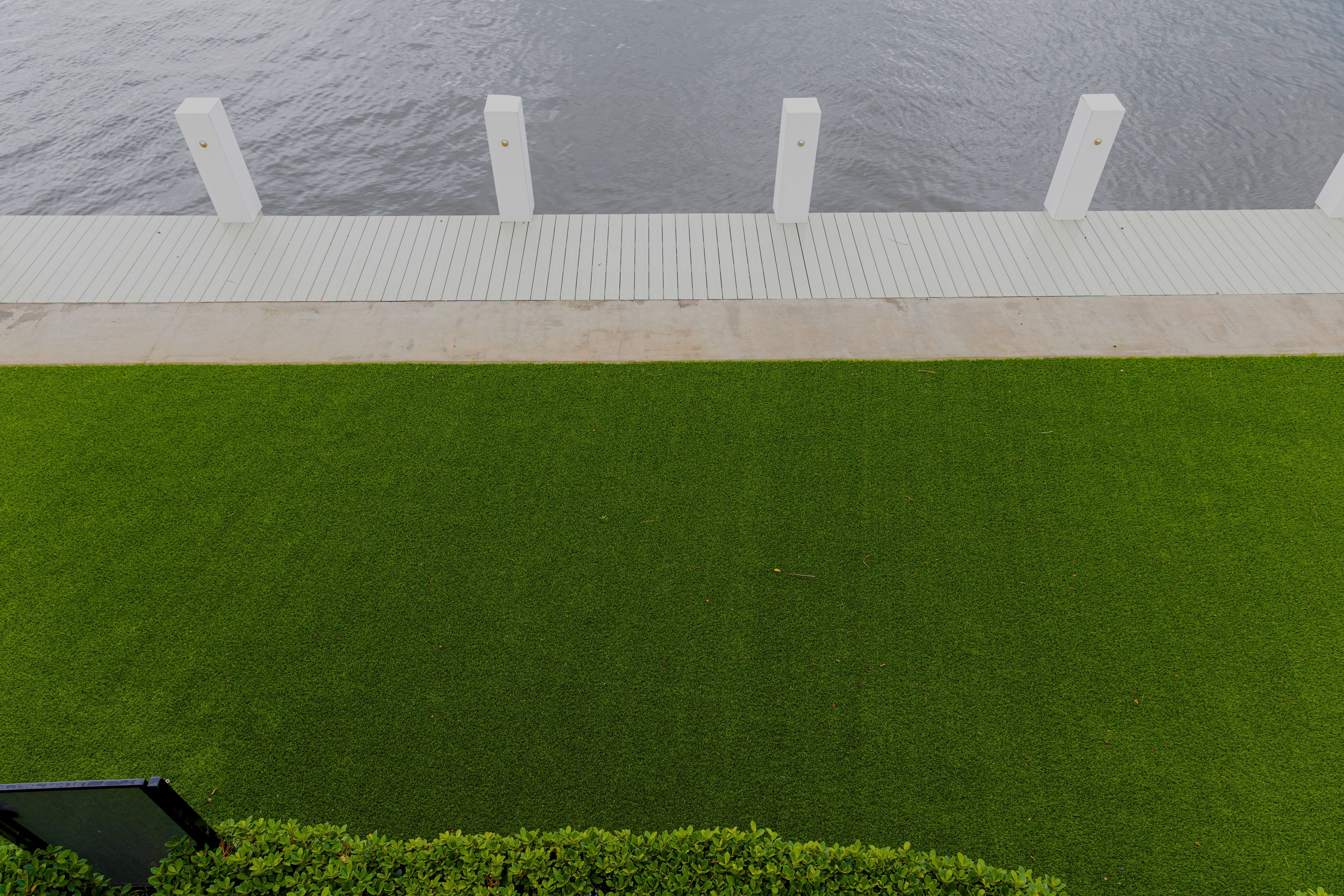Green lawn with a white pathway leading to a body of water