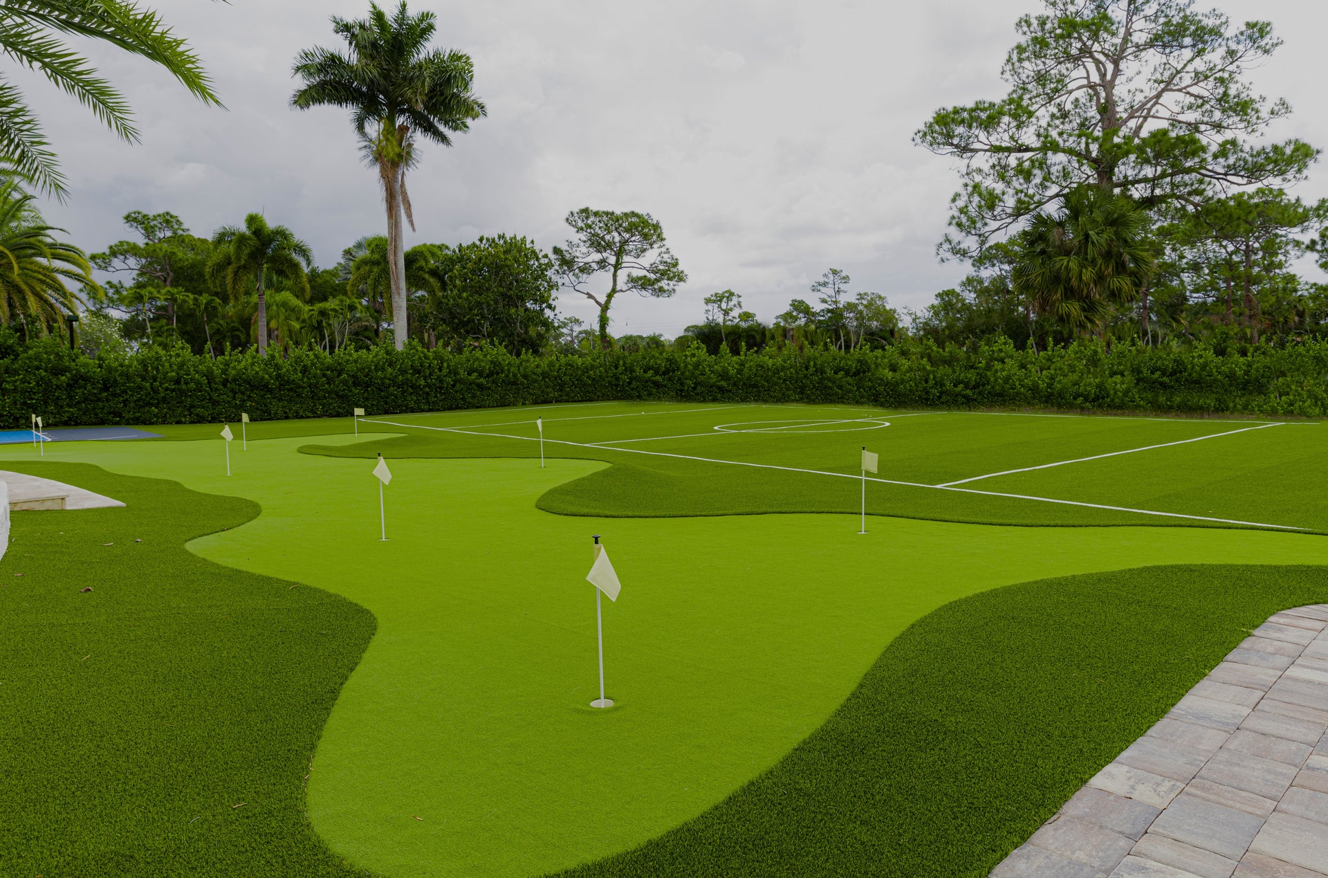 Green golf course with trees and a cloudy sky in the background